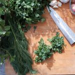 cutting board full of herbs for cooking
